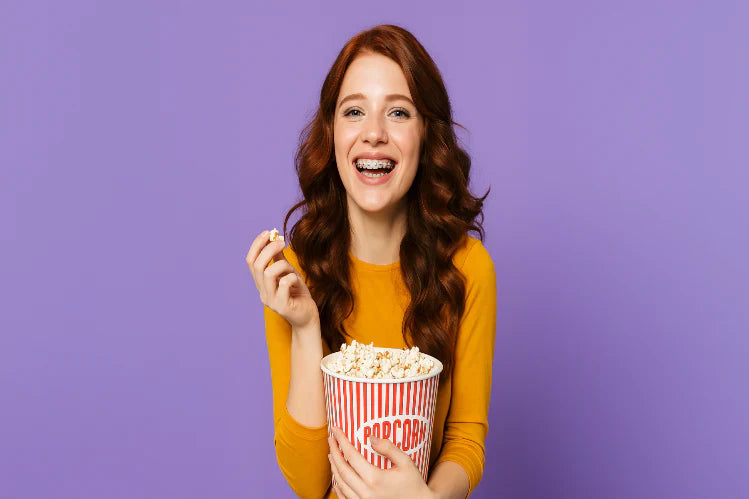 A girl with braces eating popcorn