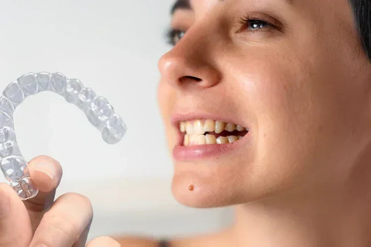 A girl holding clear aligners having crowded teeth