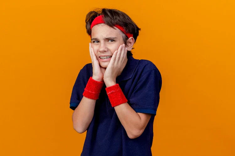 A young boy experiencing pain and orthodontic discomfort because of braces