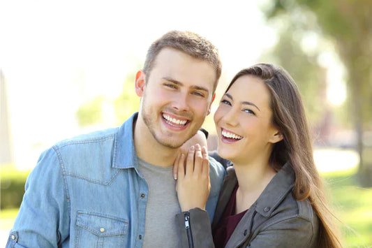 A couple with perfectly aligned teeth smiling