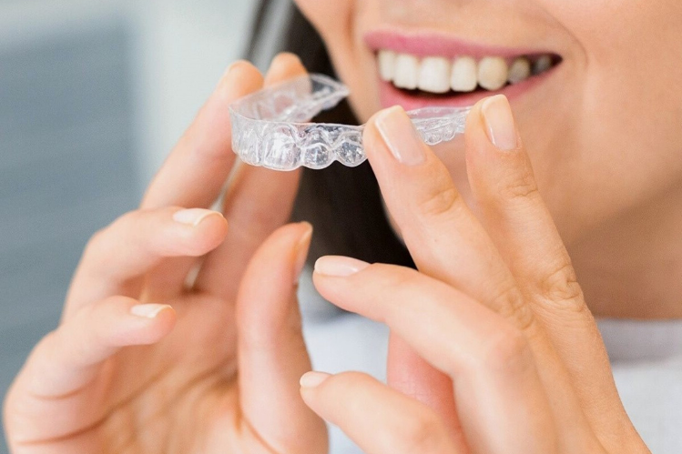 A girl putting on clear aligners