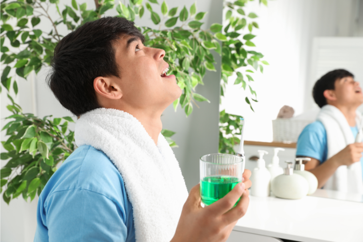 A man rinsing with mouthwash