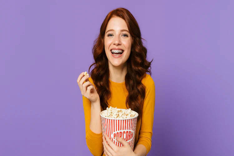 A girl with braces eating popcorn