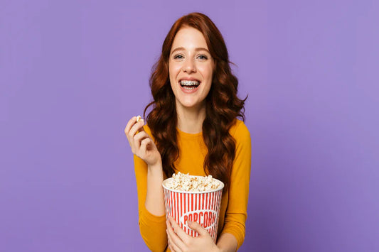 A girl with braces eating popcorn