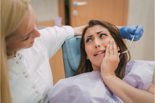 A lady showing a dentist her toothache