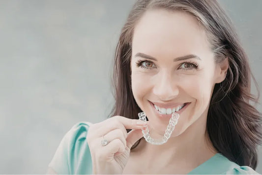  A girl applying clear aligners for teeth straightening.
