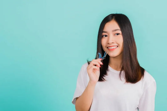 A woman holding a Hawley retainer