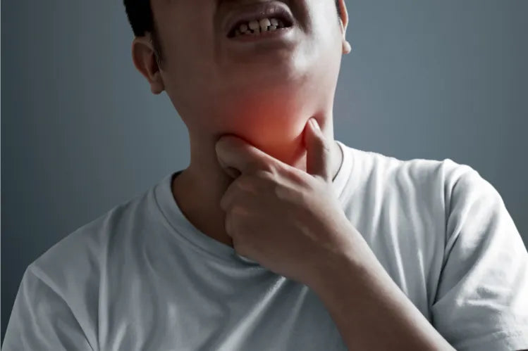 A person experiencing a sore throat after mouth guard use.