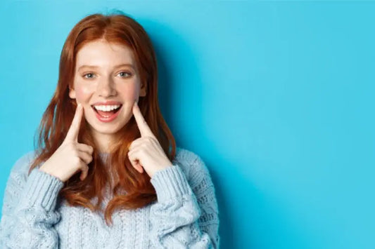 A girl is showing her whitened teeth