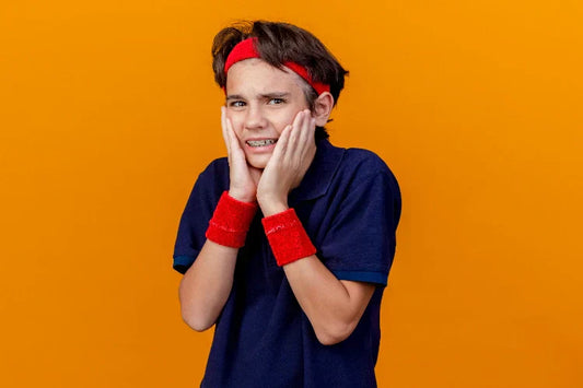A young boy experiencing pain and orthodontic discomfort because of braces
